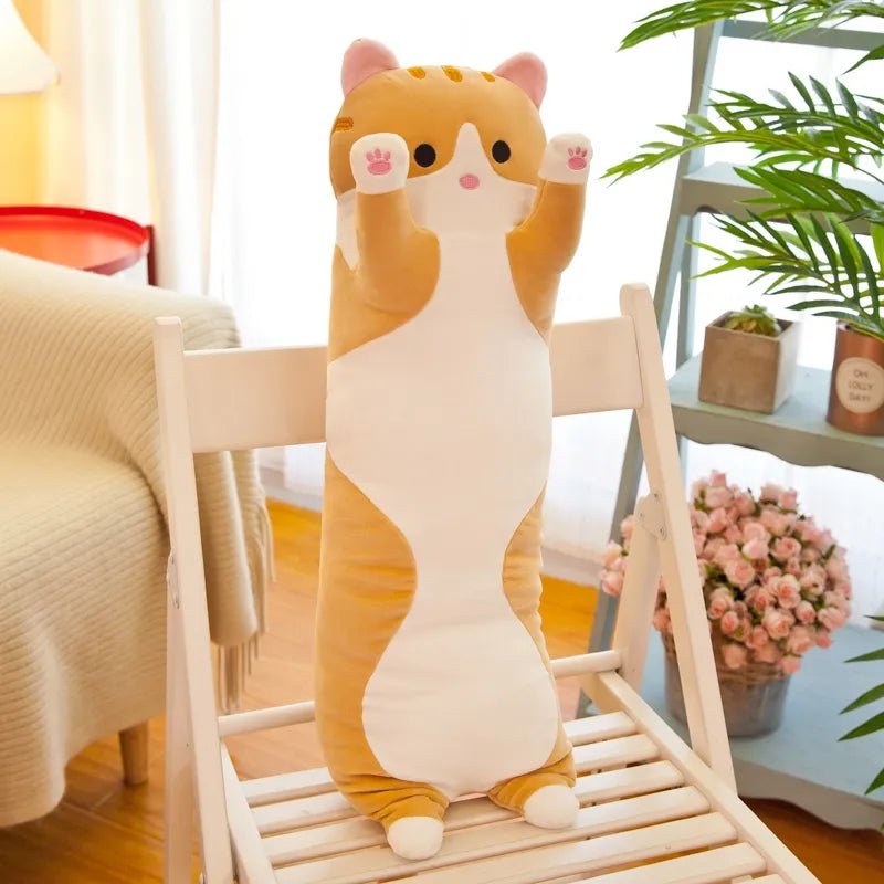Cat-shaped plush toy on a chair in a room with plants and flowers.