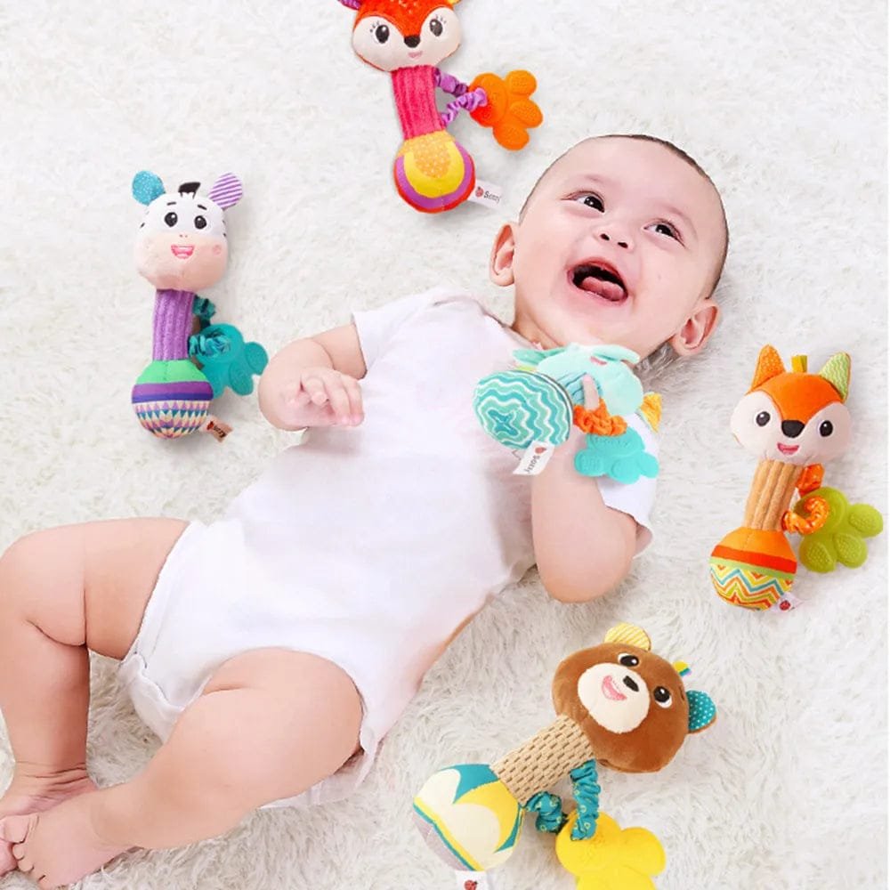 Baby lying on a white surface with colorful toys around