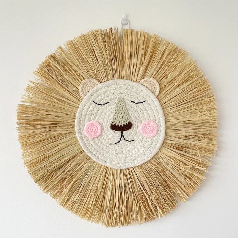 Round woven wall art of a lion face with raffia mane on a white background