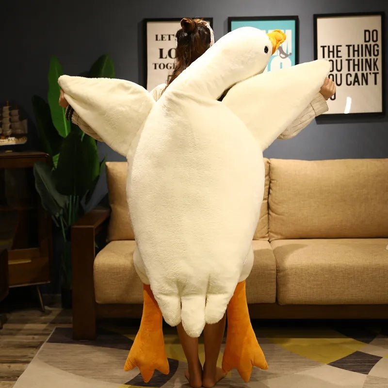 Person wearing a large goose-shaped pillow in a living room setting