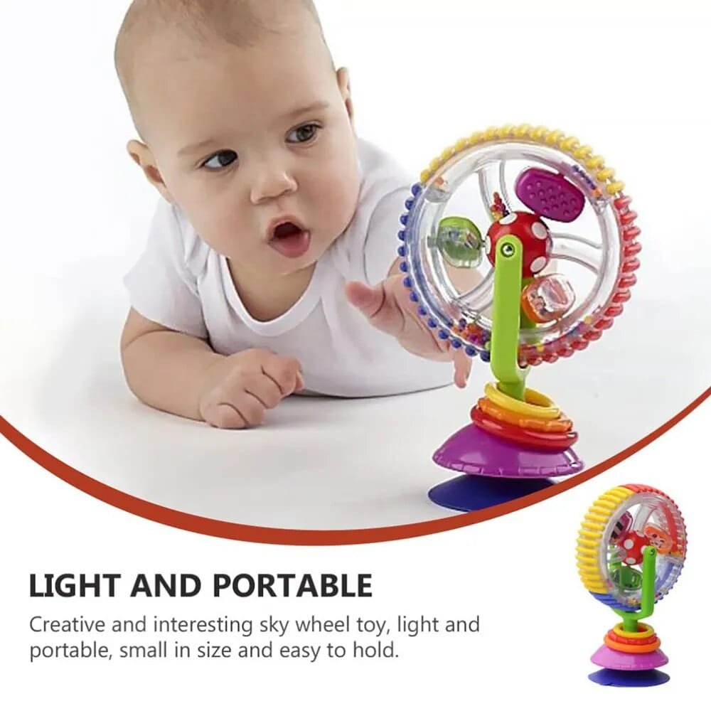 Baby playing with a colorful sky wheel toy on a white background
