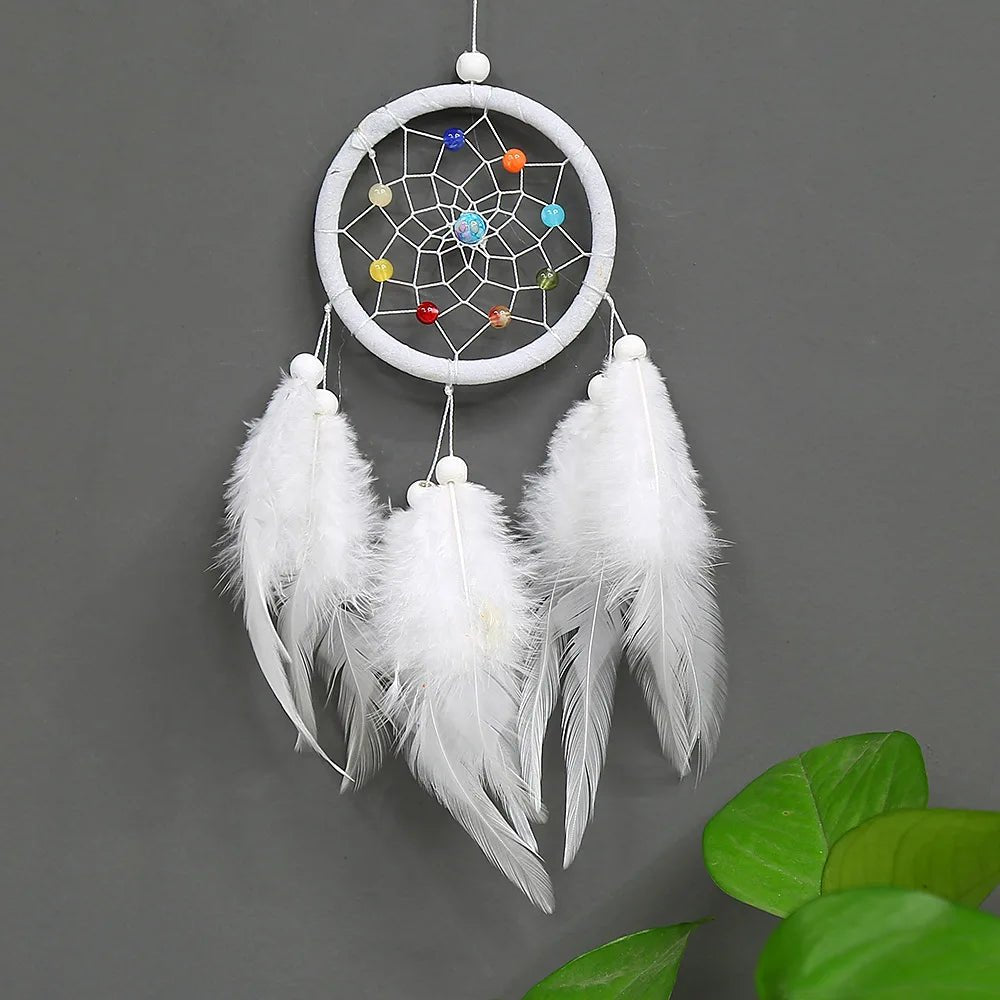 White dreamcatcher with feathers on a gray wall