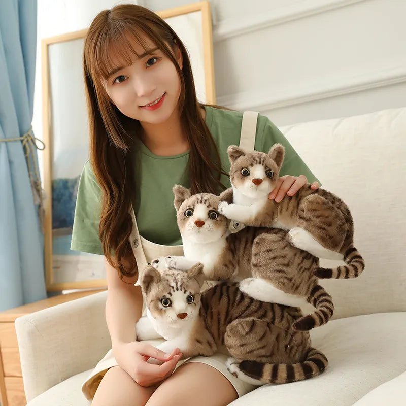 Woman holding three plush cat toys on a couch
