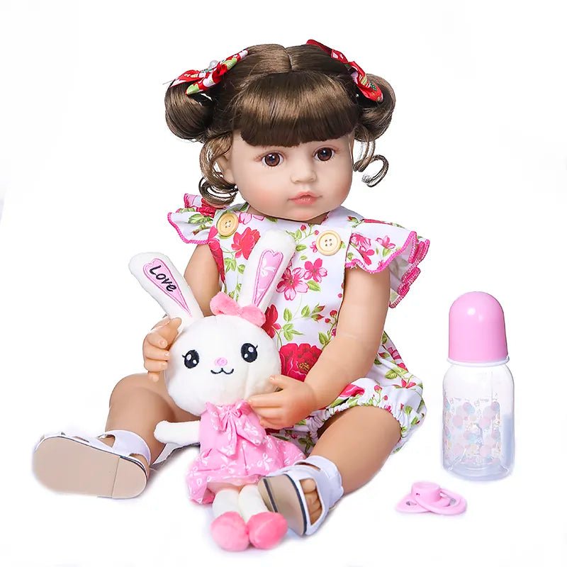 Doll with floral dress holding a plush toy and bottle on a white background