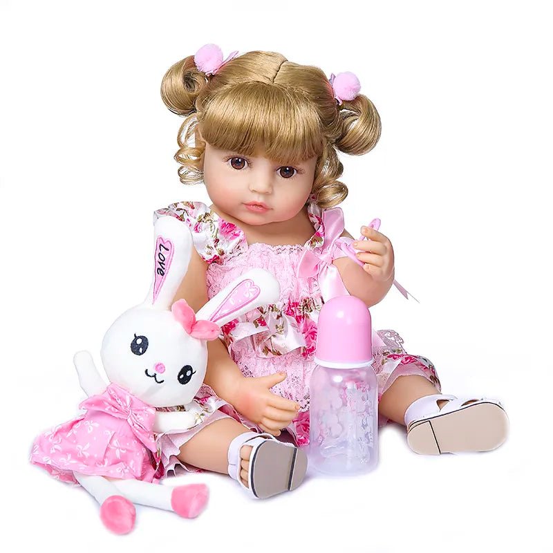 Doll with blonde hair in pigtails, wearing a pink outfit, holding a bottle and a toy