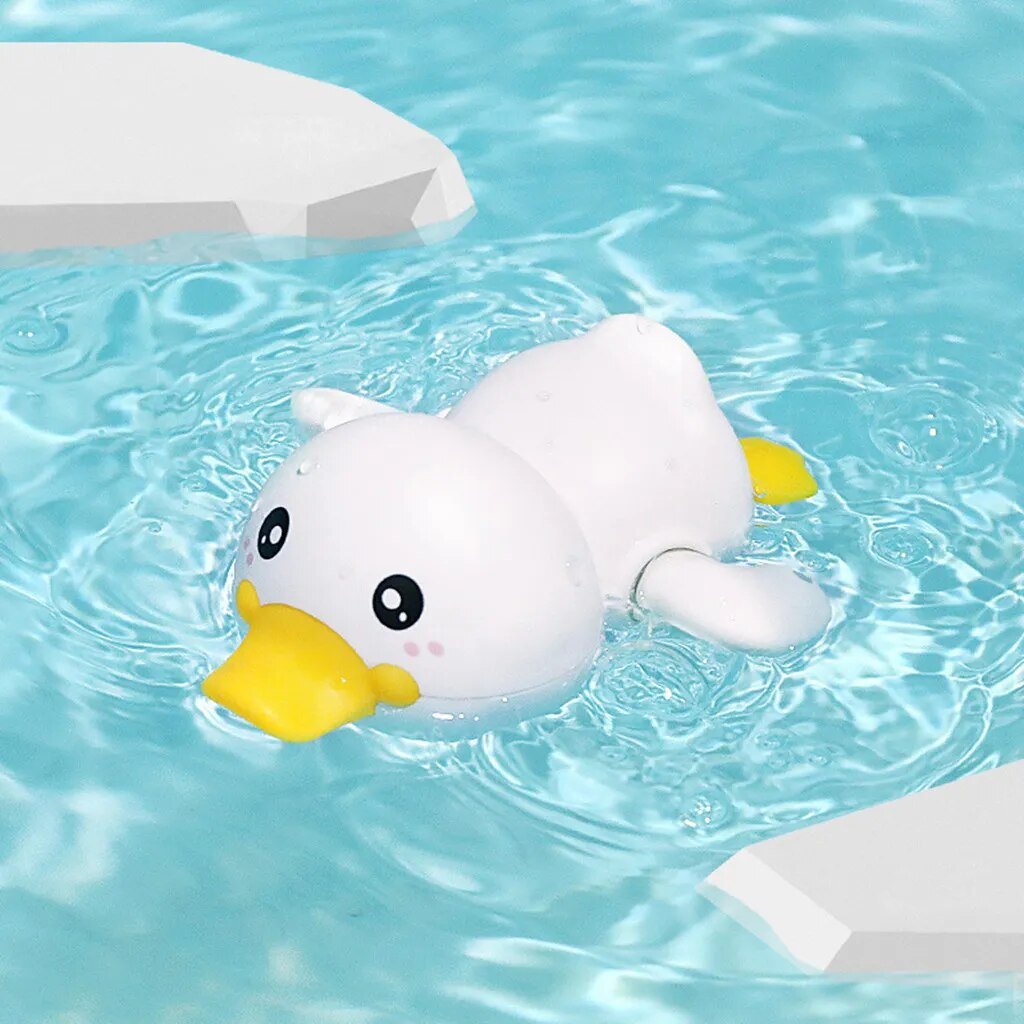White duck-shaped floatie with a yellow beak floating in clear blue water.