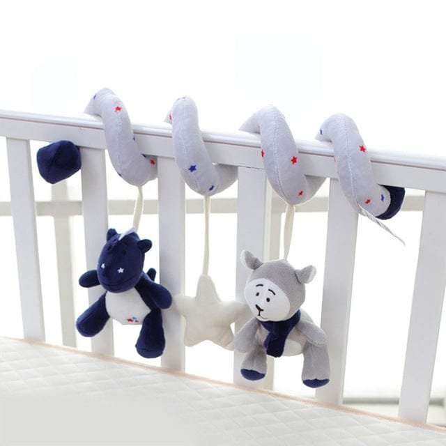 Plush toy rattles hanging from a crib rail with a white background