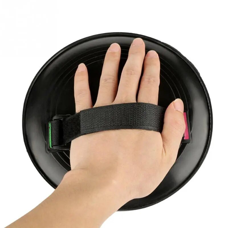 Hand holding a black suction cup with a strap on a white background
