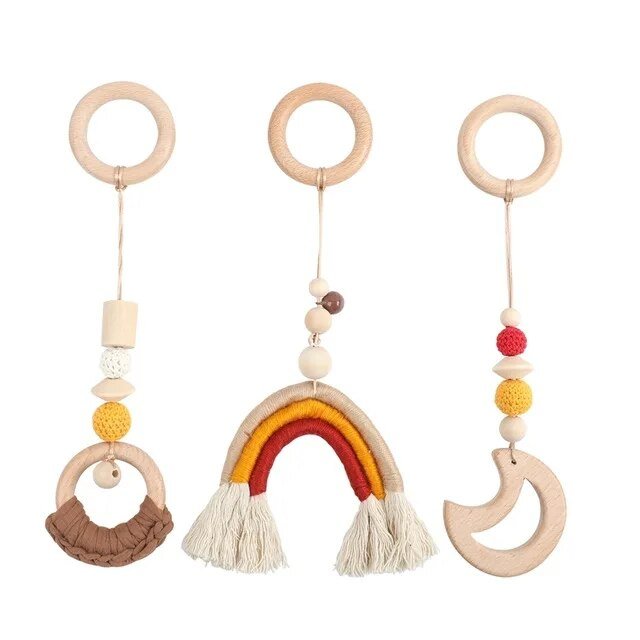 Three wooden baby rattle toys with colorful beads and tassels on a white background