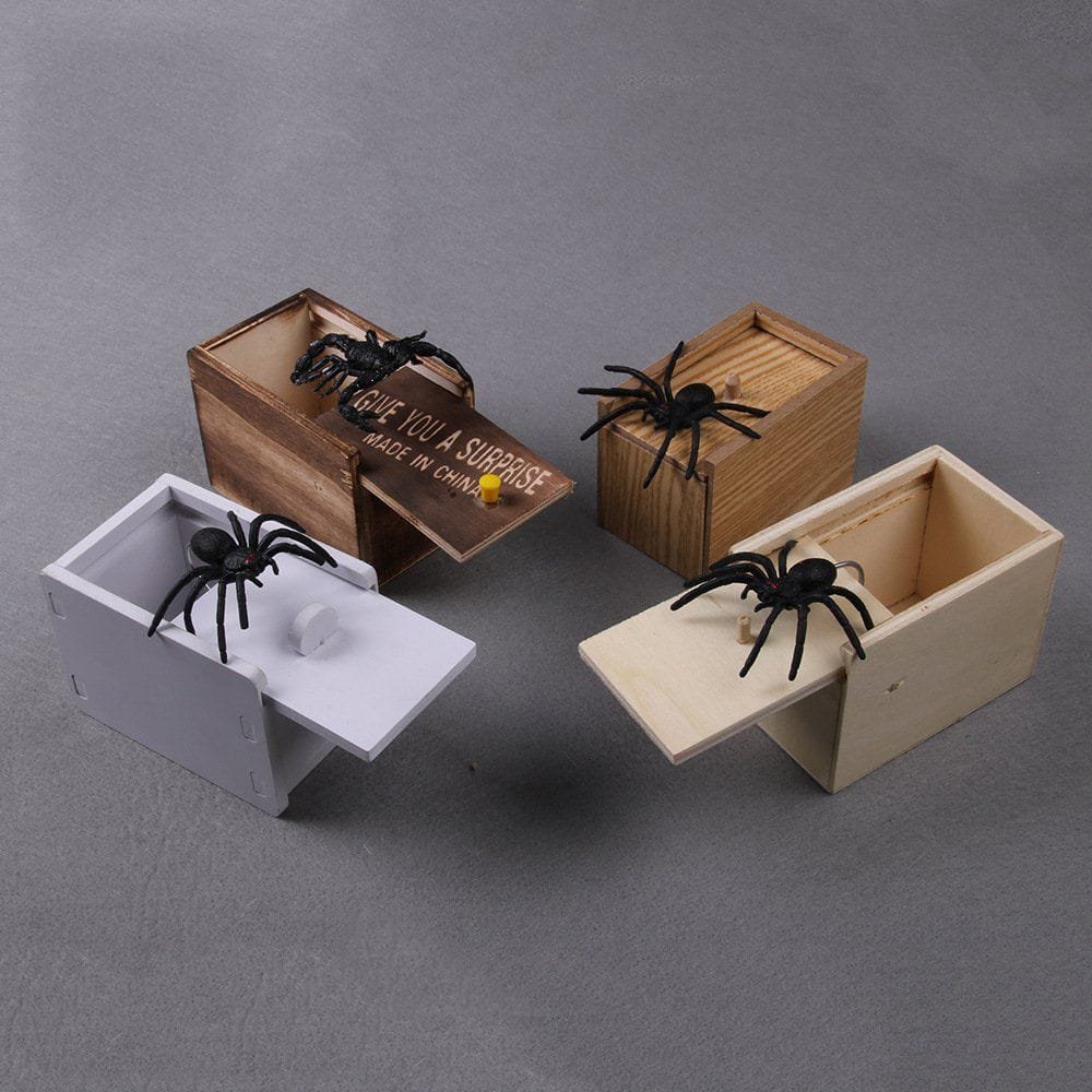 Three wooden boxes with spiders on a gray background