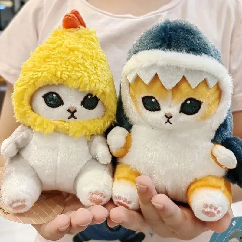 Two plush toys resembling cats in animal costumes held by a person.