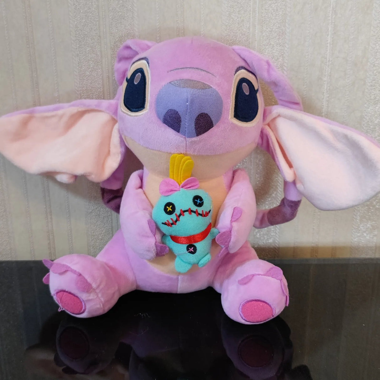 Plush toy with a character inside, sitting on a reflective surface.