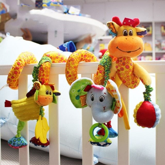 Colorful baby crib toys hanging on a crib rail.