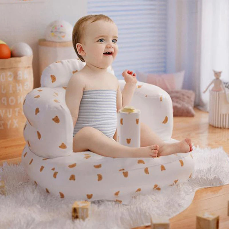 Baby sitting in a cloud-shaped inflatable chair in a room with toys and furniture.