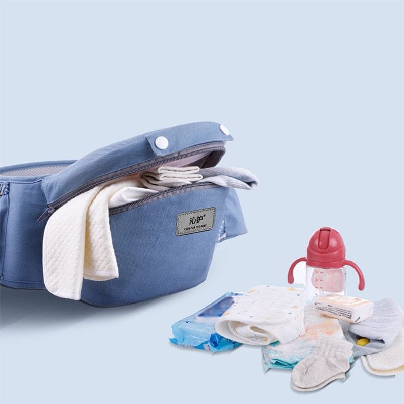 Blue baby carrier with baby items on a light blue background