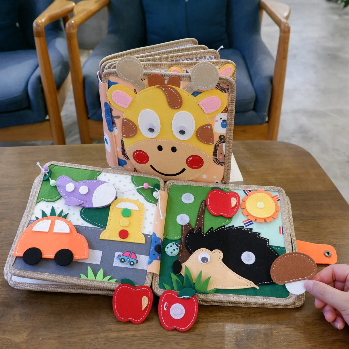 Children's felt board with animal and vehicle designs on a wooden table.