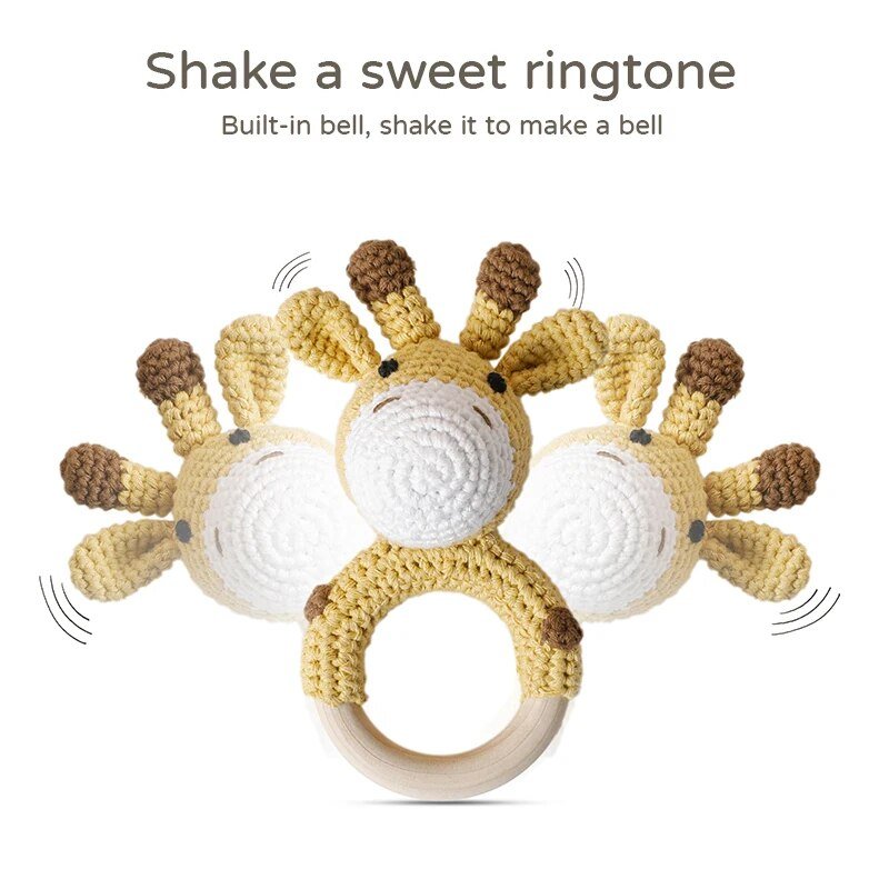 Crocheted giraffe rattle with a wooden ring on a white background