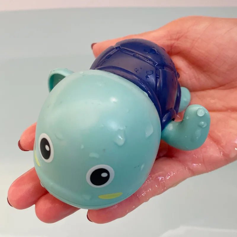 Toy turtle with a blue shell held in a hand.