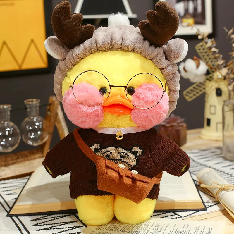 Plush toy duck wearing glasses, a sweater, and a hat with antlers on a decorative surface.