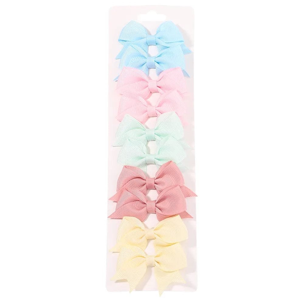 Set of pastel-colored hair bows in a clear package on a white background