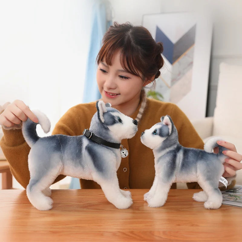A woman playing with two plush husky toys