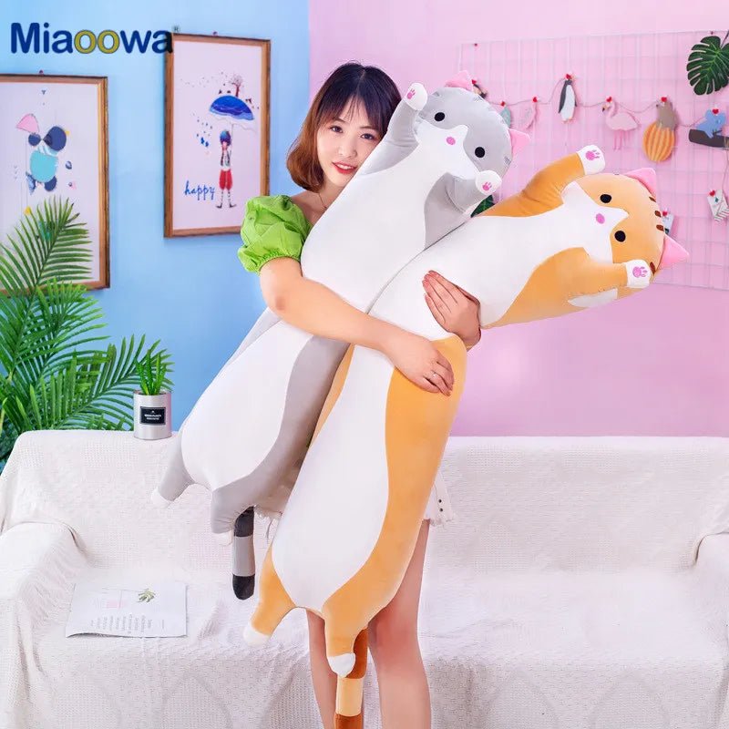 Woman holding a large plush toy shaped like a cat and dog.