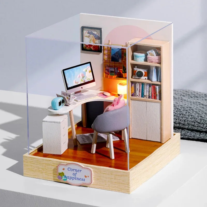 Miniature office setup with a desk, chair, and bookshelf inside a clear acrylic box.