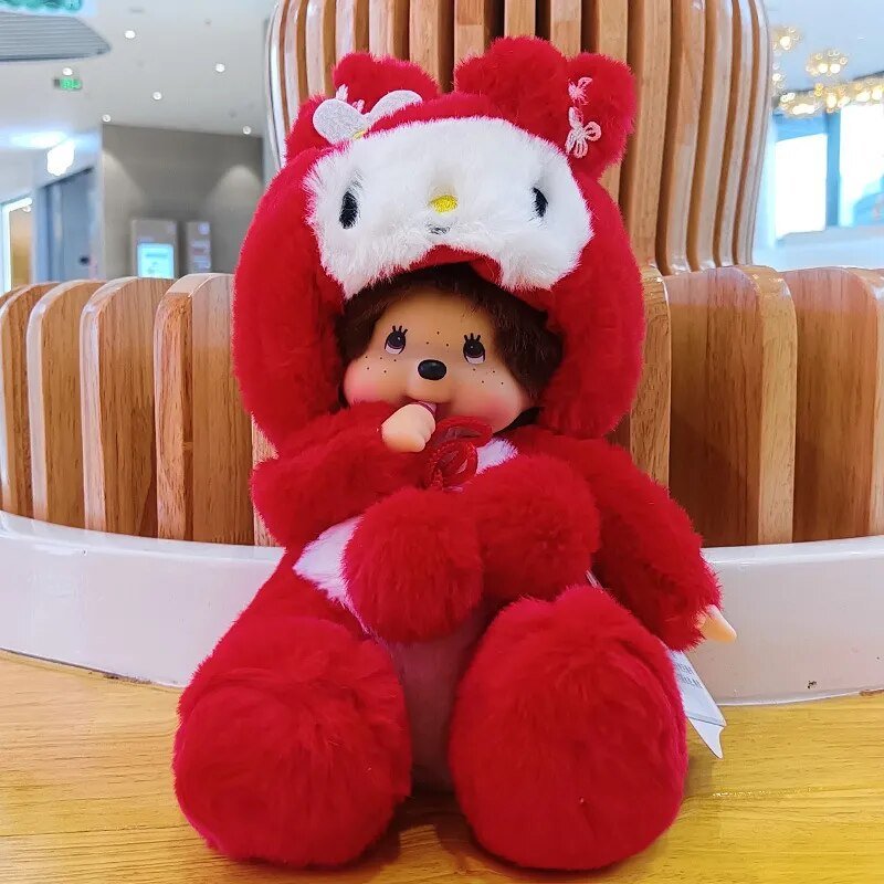 Red plush toy with a white face and black eyes, sitting on a wooden surface.