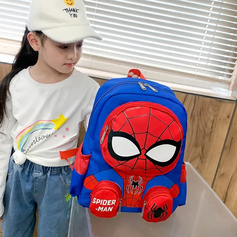 Child holding a Spider-Man backpack indoors