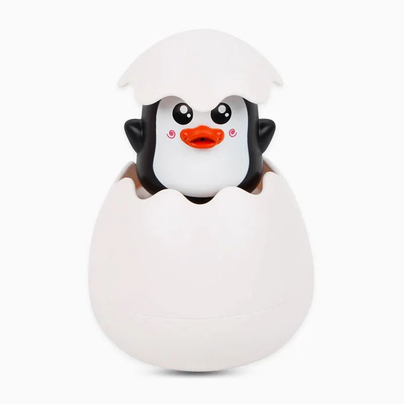 Penguin toy emerging from a white egg.