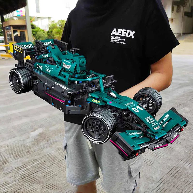 Person holding a detailed model of a racing car with 'AEEIX' branding