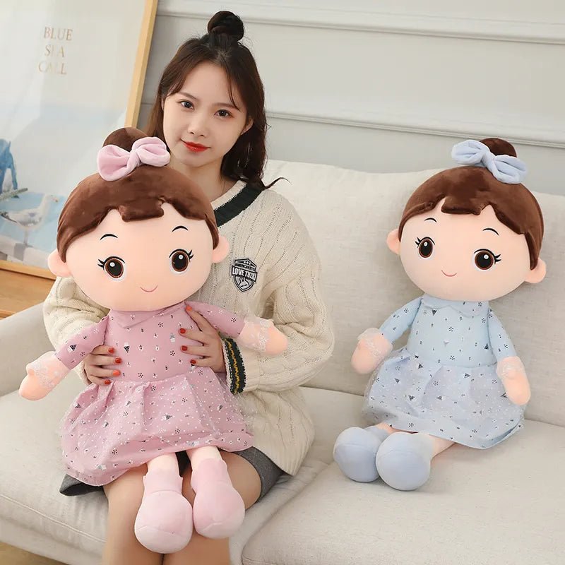 Woman holding a plush toy with another plush toy next to her on a couch.