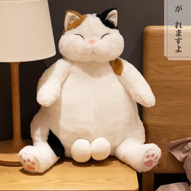 Plush cat toy sitting on a wooden surface.