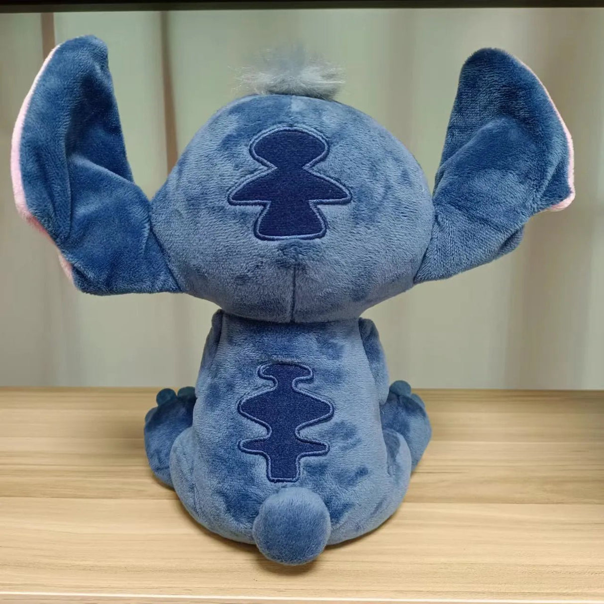 Blue plush toy with a distinctive logo