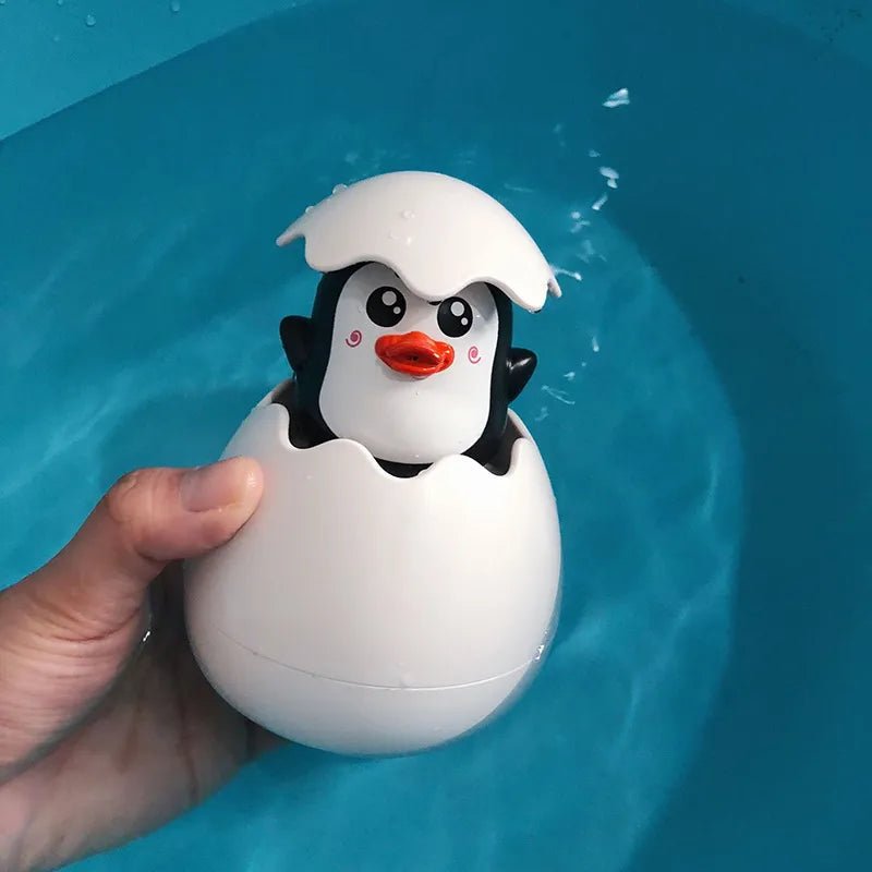 Penguin toy in an eggshell being held over water