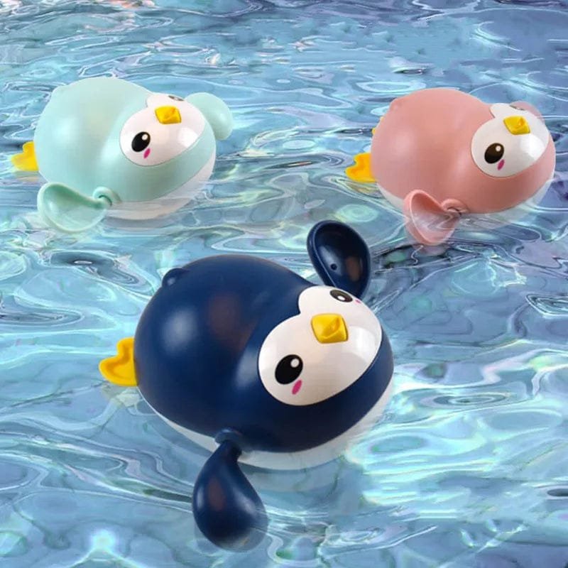 Three cartoon-style penguin bath toys floating on water.