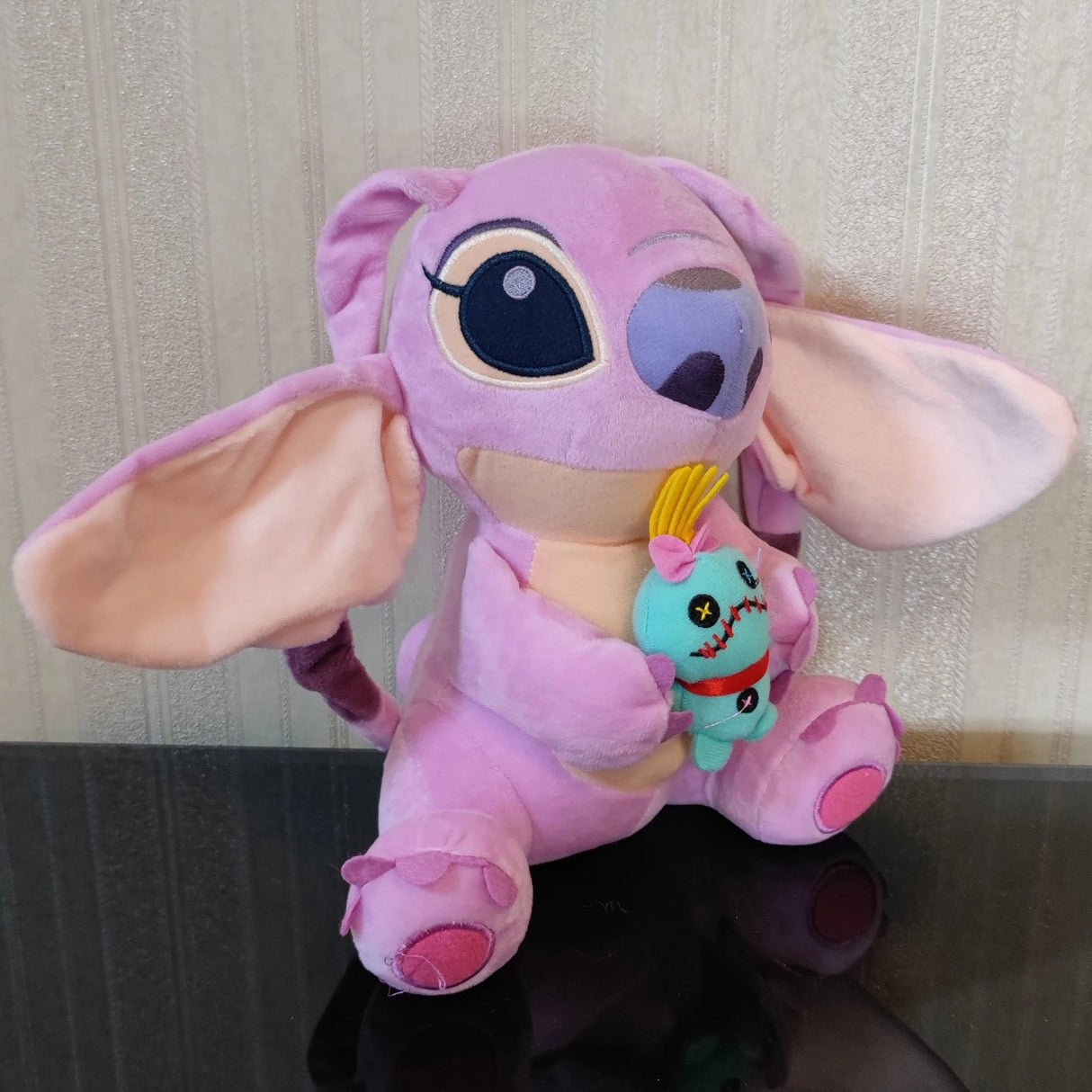 Pink plush toy with a small blue character attached.