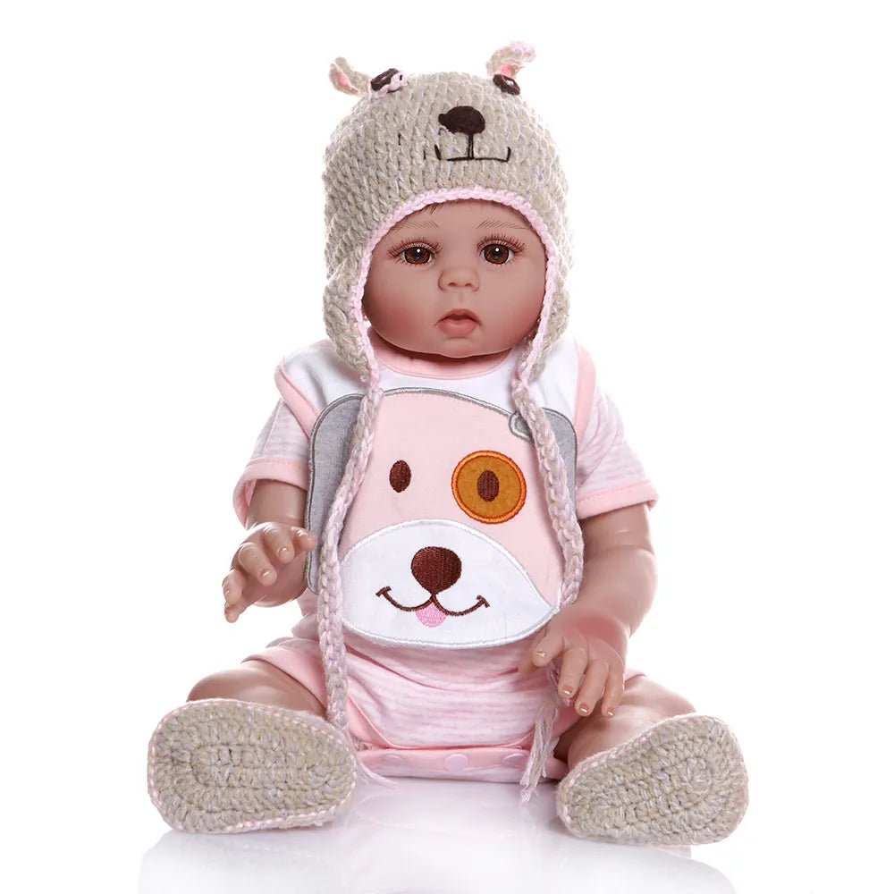 Baby doll in a pink outfit with a bear hat.
