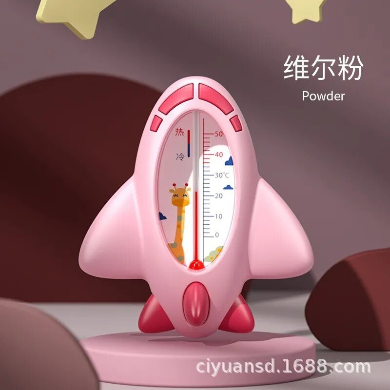 Pink rocket-shaped thermometer with a cartoon character on a dark background