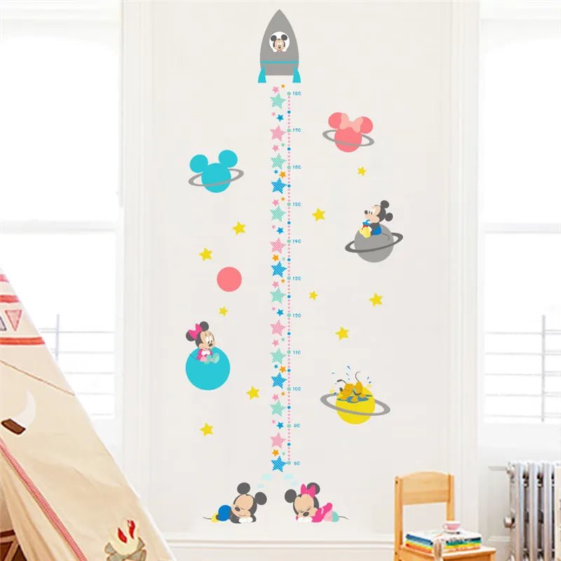 Children's growth chart with space-themed design on a white wall.