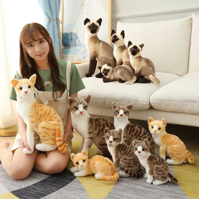 Woman holding a cat plush toy with actual cats on a couch
