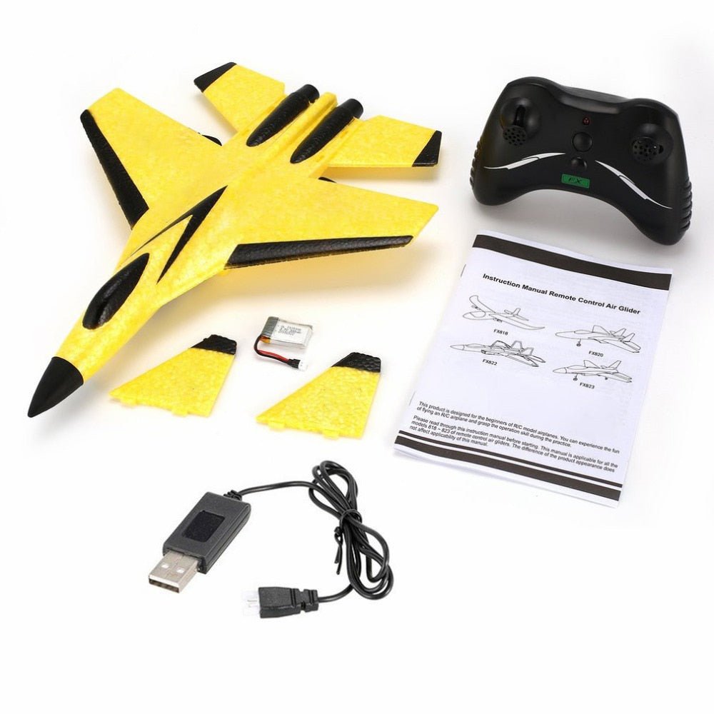 Yellow and black remote control airplane kit with controller, USB cable, and manual.