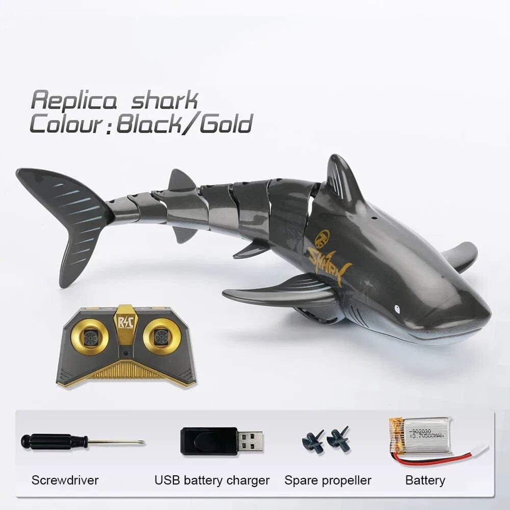 Replica shark toy with remote control, screwdriver, USB charger, spare propeller, and battery.