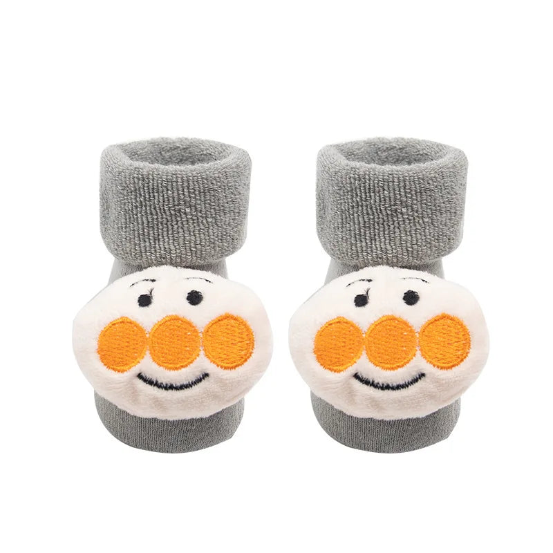 Pair of baby booties with gray tops and white bottoms featuring orange circles and black dots on a white background.