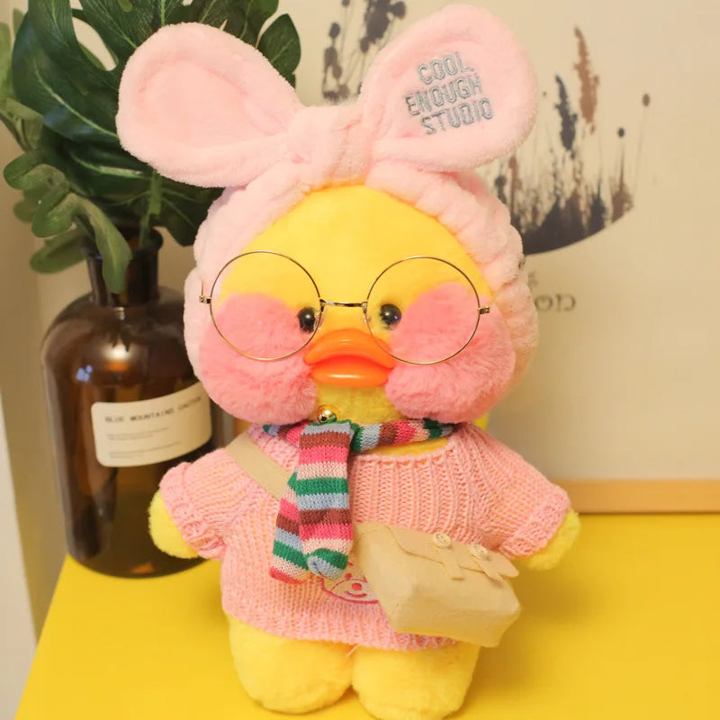 Plush toy duck with pink sweater and glasses on a yellow surface