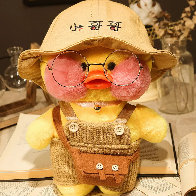 Yellow plush toy with glasses and a hat on a table with books and decorative items.