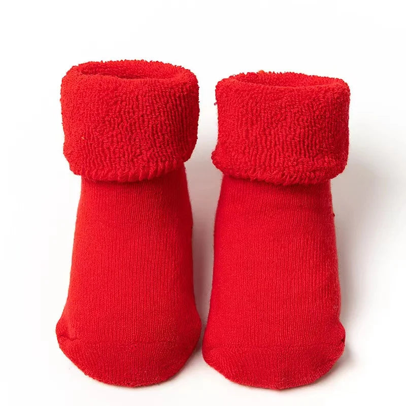 Pair of red baby socks on a white background