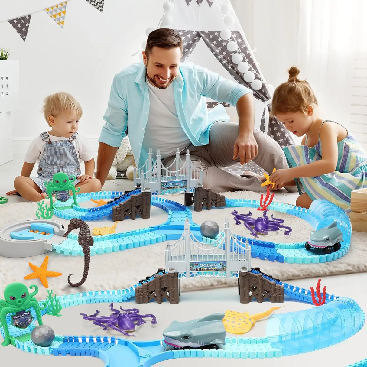 Man and two children playing with a marine-themed toy track set