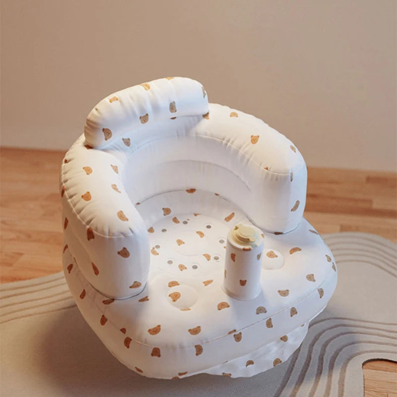 White baby seat with brown heart patterns on a wooden floor.