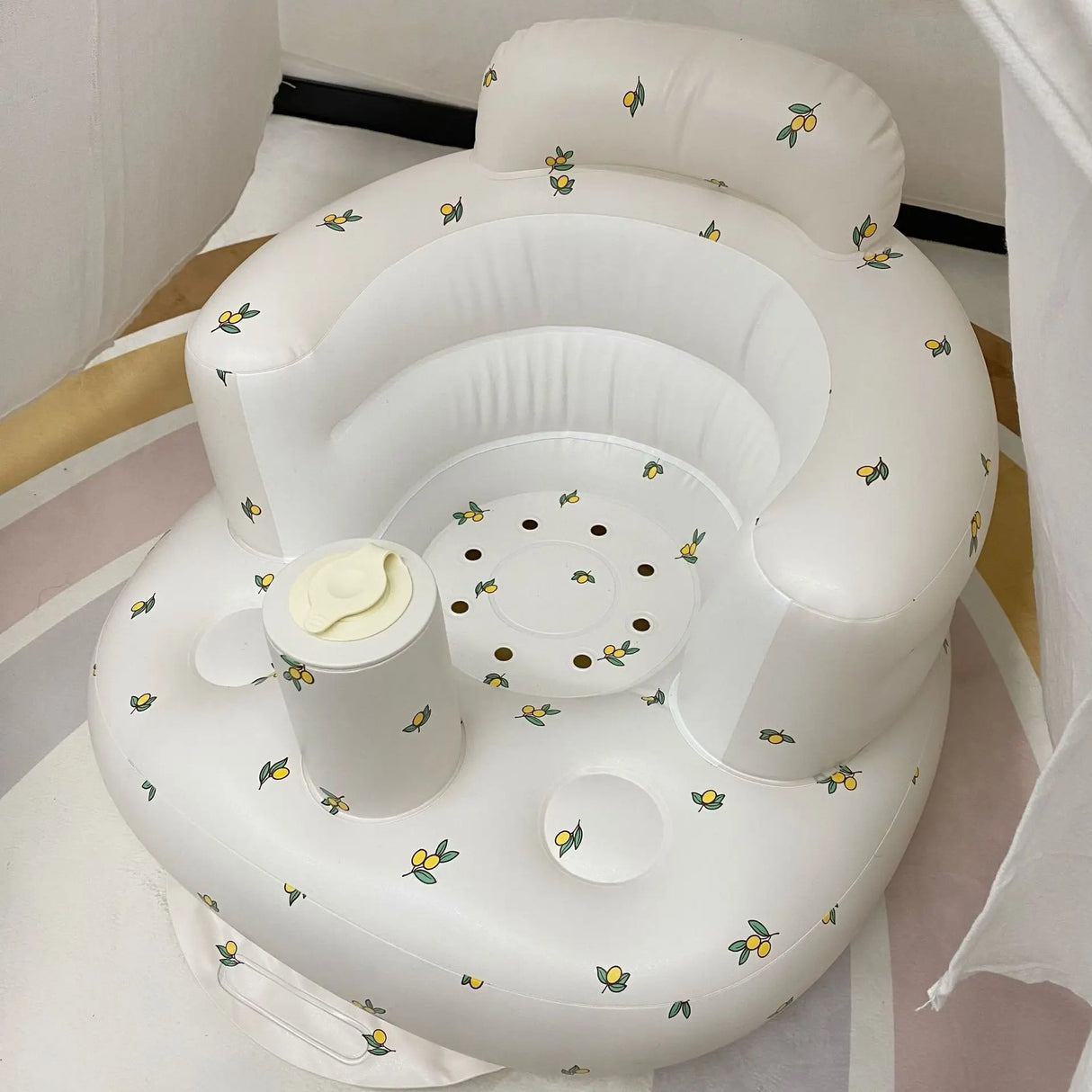 White inflatable baby seat with floral patterns on a white background
